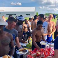 Football team getting food from full table